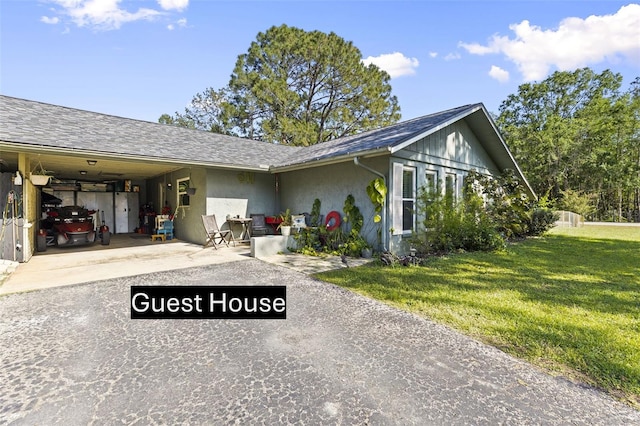 2400 Commack Ct, New Port Richey, FL 34655 - view of front of house featuring driveway, a carport, a front lawn, and stucco siding