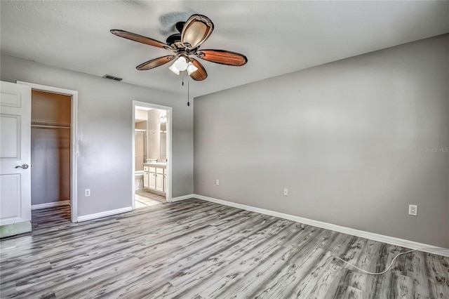 4030 Casa Del Sol Way, New Port Richey, FL 34655 - unfurnished bedroom with light wood finished floors, visible vents, a walk in closet, a closet, and baseboards