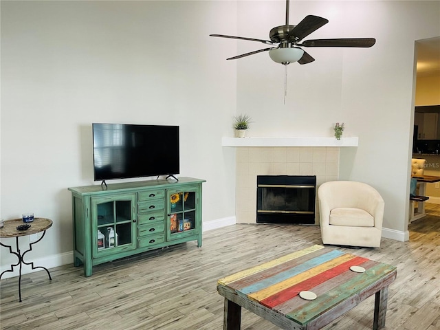 2729 Penzance St, Palm Harbor, FL 34684 - living room featuring baseboards, ceiling fan, wood finished floors, and a tile fireplace