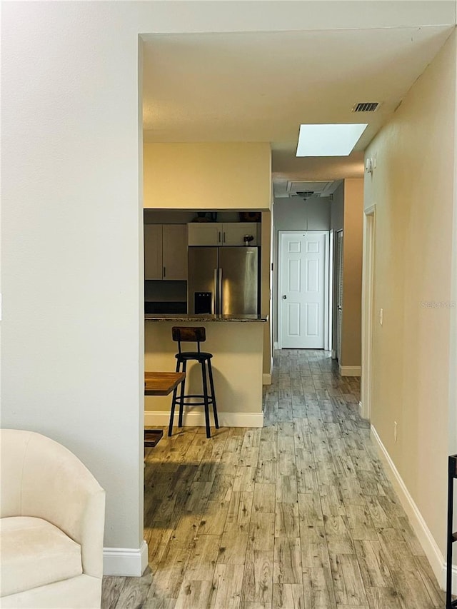 2729 Penzance St, Palm Harbor, FL 34684 - interior space featuring stainless steel fridge, a breakfast bar area, light wood-type flooring, and visible vents