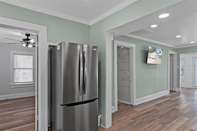 kitchen featuring freestanding refrigerator, wood finished floors, crown molding, and baseboards