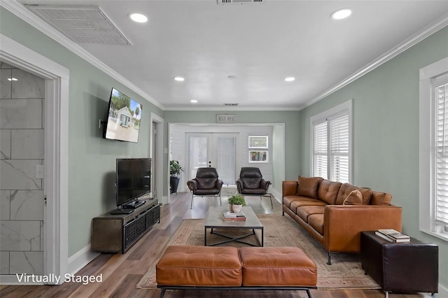 living area featuring crown molding, wood finished floors, baseboards, visible vents, and recessed lighting