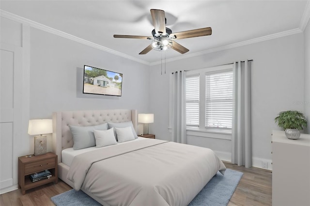 bedroom featuring ceiling fan, light wood-style flooring, and ornamental molding