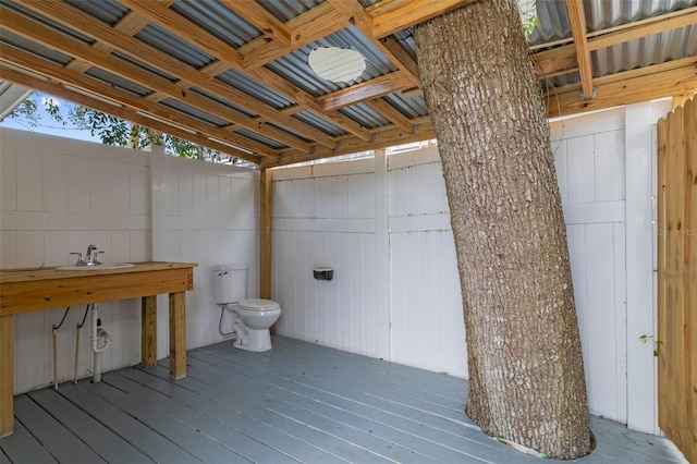 exterior space featuring hardwood / wood-style flooring, a sink, and toilet