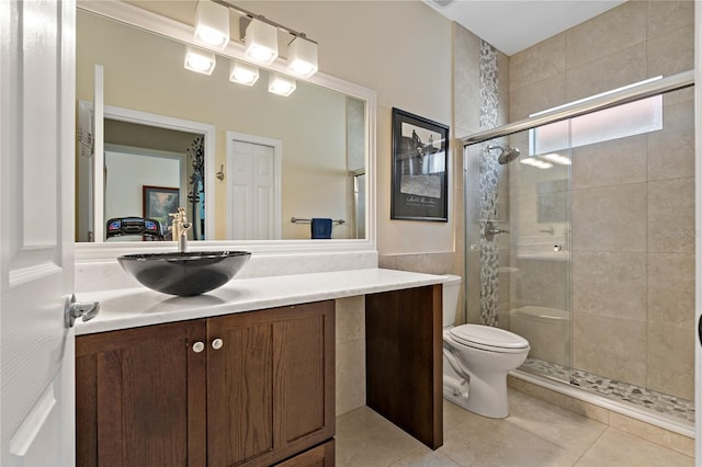 full bath with a stall shower, toilet, vanity, and tile patterned floors