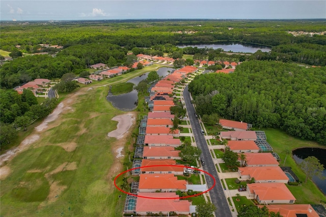 aerial view of residential area featuring a large body of water, a forest, and a local golf course
