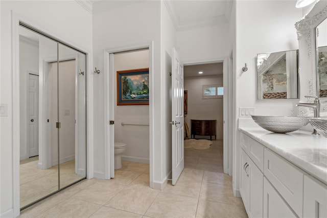 bathroom with ornamental molding, toilet, vanity, tile patterned floors, and baseboards