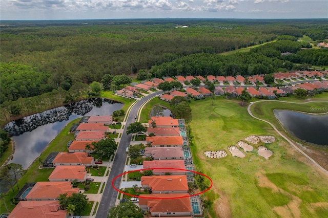 aerial view of residential area featuring a heavily wooded area, a large body of water, and a golf club