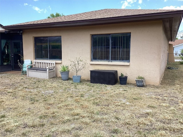 13111 Sheridan Dr, Hudson, FL 34667 - view of property exterior featuring stucco siding, a yard, and a shingled roof