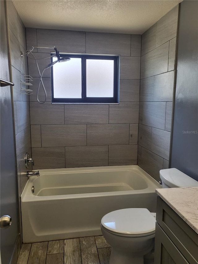 13111 Sheridan Dr, Hudson, FL 34667 - bathroom featuring toilet, vanity, bathtub / shower combination, wood finish floors, and a textured ceiling