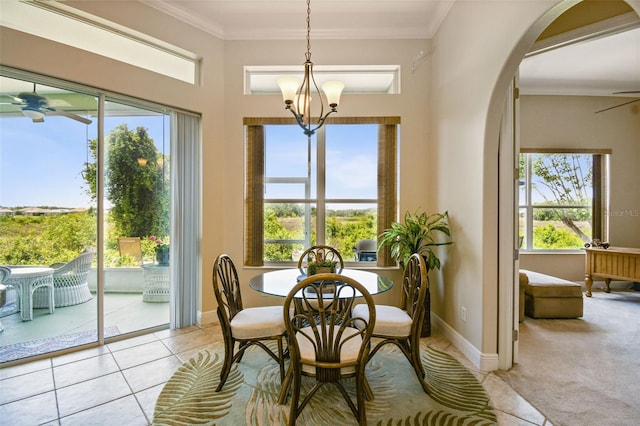 dining area featuring arched walkways, ceiling fan, ornamental molding, and a wealth of natural light