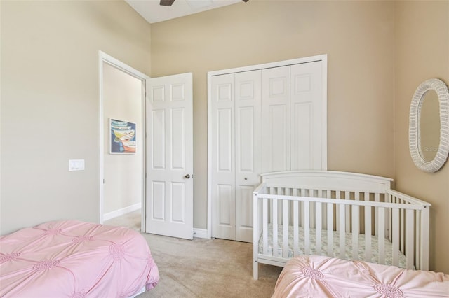bedroom featuring baseboards, light colored carpet, and a closet