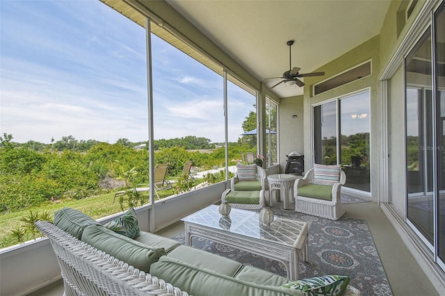 sunroom with a ceiling fan and an outdoor living space