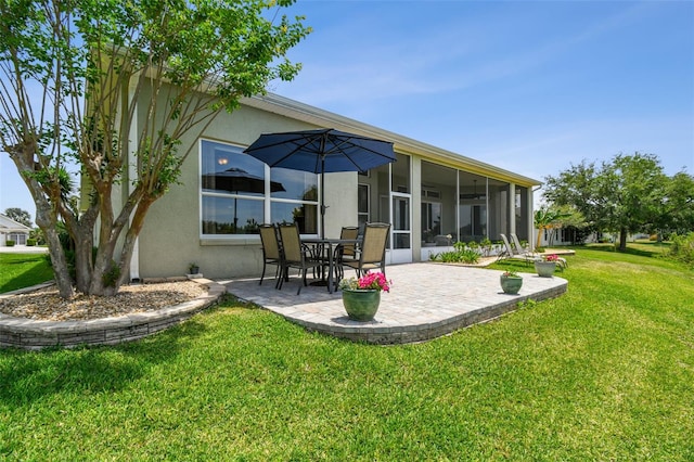back of house with a lawn, stucco siding, and a patio area