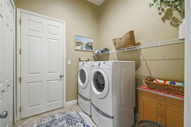 laundry area with light tile patterned floors, baseboards, laundry area, and independent washer and dryer