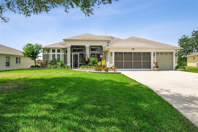 prairie-style home featuring an attached garage, driveway, a front yard, and stucco siding