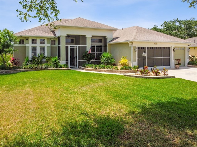 prairie-style home featuring a garage, a front yard, stucco siding, a sunroom, and driveway