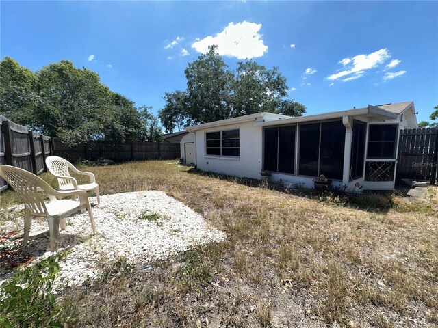 view of yard with a sunroom and a fenced backyard
