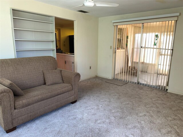 living room with visible vents, carpet floors, and ceiling fan