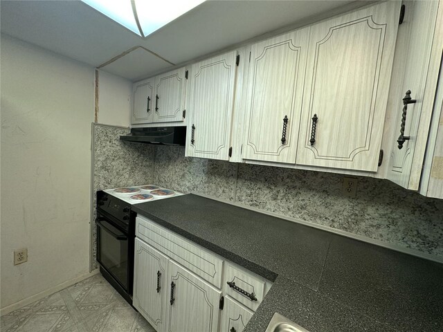 kitchen with white cabinets, dark countertops, baseboards, black / electric stove, and under cabinet range hood