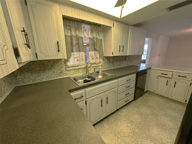 kitchen featuring dark countertops, a sink, dishwasher, a peninsula, and visible vents