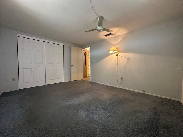 unfurnished bedroom featuring carpet flooring, ceiling fan, baseboards, visible vents, and a closet