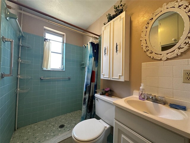 full bath featuring vanity, a tile shower, and toilet