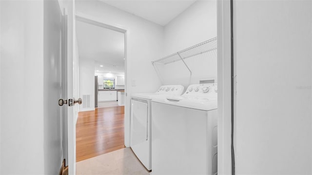 laundry room with laundry area, visible vents, and washing machine and dryer