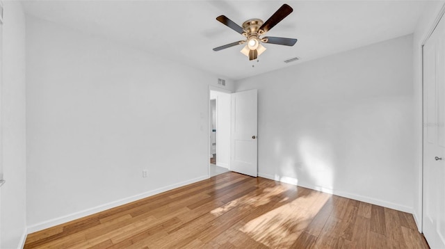 spare room with visible vents, baseboards, and wood finished floors