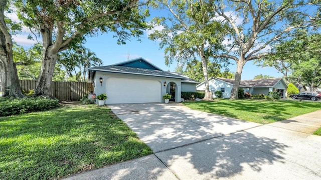 ranch-style house featuring a garage, fence, a front yard, stucco siding, and driveway