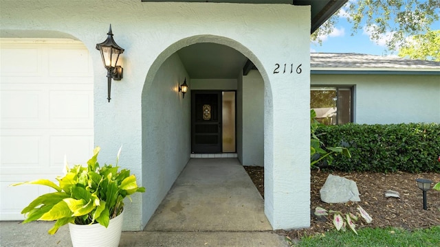 doorway to property featuring stucco siding