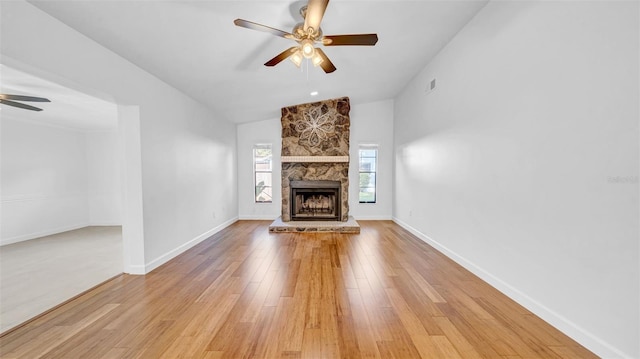 unfurnished living room featuring light wood finished floors, a fireplace, a ceiling fan, lofted ceiling, and visible vents