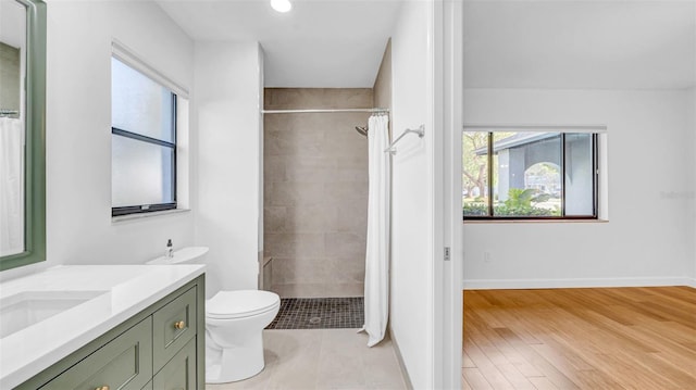 full bath featuring toilet, a tile shower, and vanity