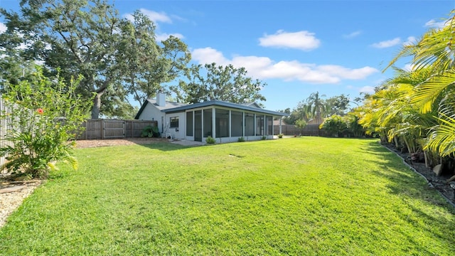 view of yard with a sunroom and a fenced backyard