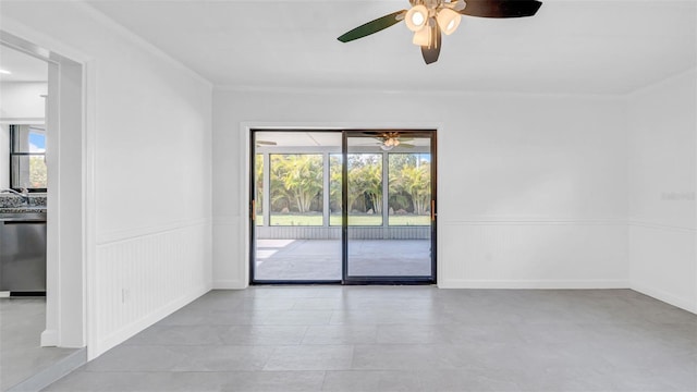 unfurnished room featuring plenty of natural light, wainscoting, and ceiling fan