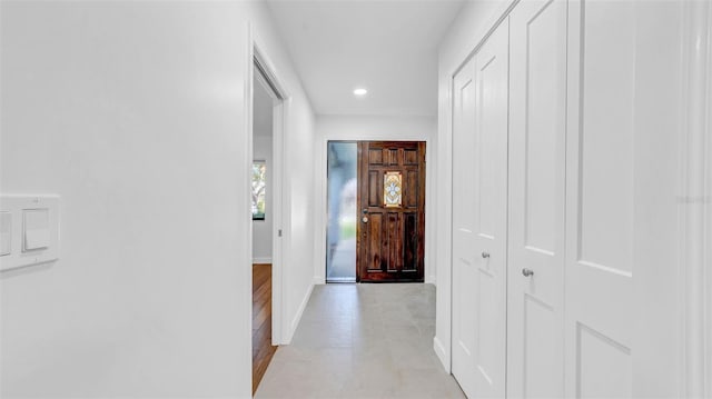 hall with recessed lighting and baseboards
