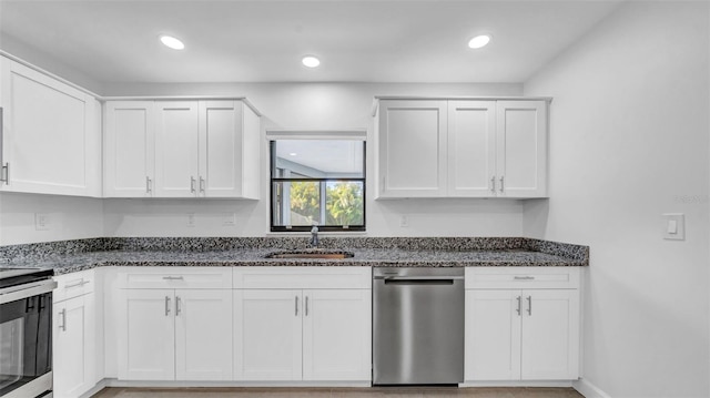 kitchen with a sink, stainless steel appliances, and dark stone countertops