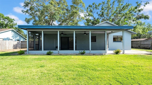 back of house with a sunroom, ceiling fan, a lawn, and fence