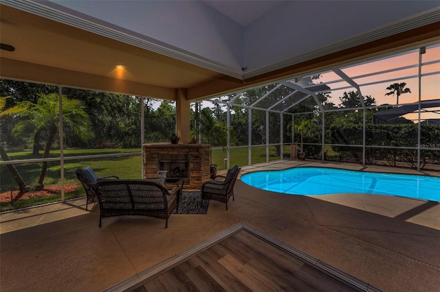 1033 Tuscany Dr, Trinity, FL 34655 - pool at dusk with a patio, an outdoor pool, an outdoor living space with a fireplace, a lawn, and a lanai