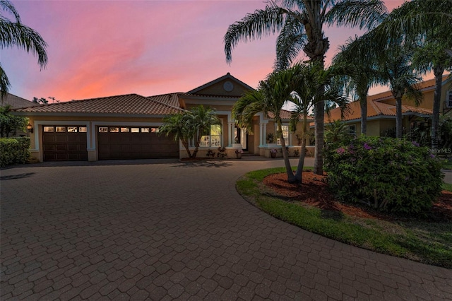 1033 Tuscany Dr, Trinity, FL 34655 - mediterranean / spanish-style home with stucco siding, curved driveway, a tile roof, and a garage
