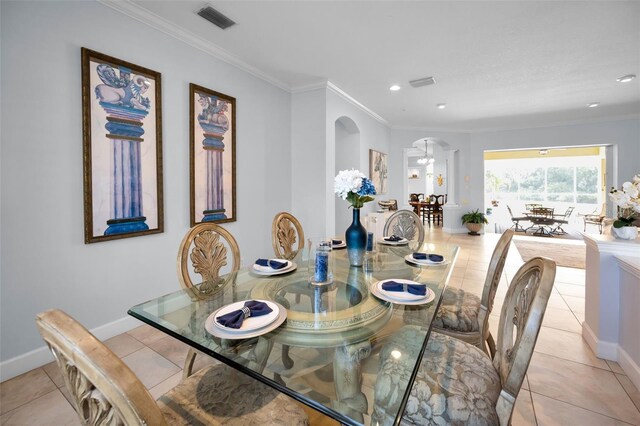 1033 Tuscany Dr, Trinity, FL 34655 - dining space featuring crown molding, arched walkways, visible vents, and light tile patterned flooring
