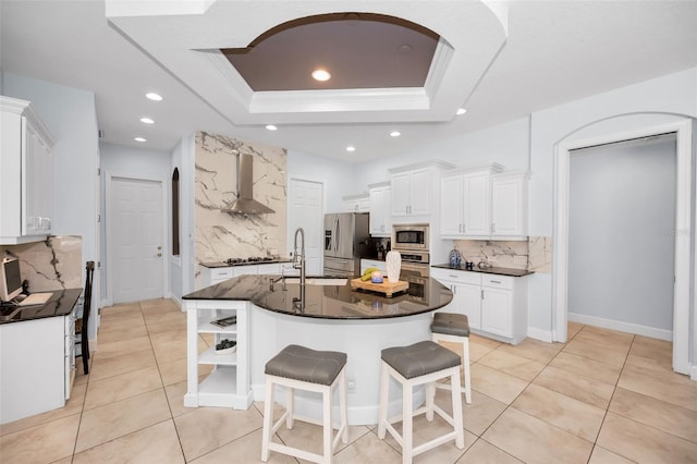 1033 Tuscany Dr, Trinity, FL 34655 - kitchen with wall chimney range hood, appliances with stainless steel finishes, tasteful backsplash, a sink, and a raised ceiling