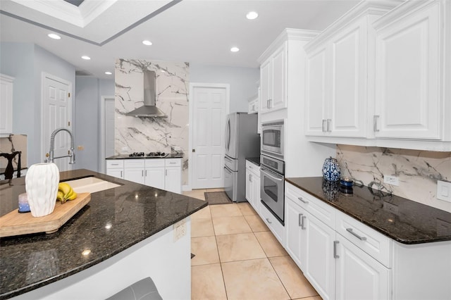 1033 Tuscany Dr, Trinity, FL 34655 - kitchen featuring appliances with stainless steel finishes, tasteful backsplash, white cabinetry, a sink, and wall chimney exhaust hood