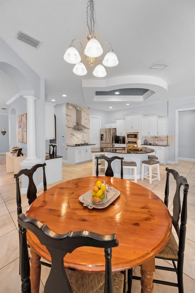 1033 Tuscany Dr, Trinity, FL 34655 - dining area featuring visible vents, a tray ceiling, arched walkways, light tile patterned floors, and a notable chandelier