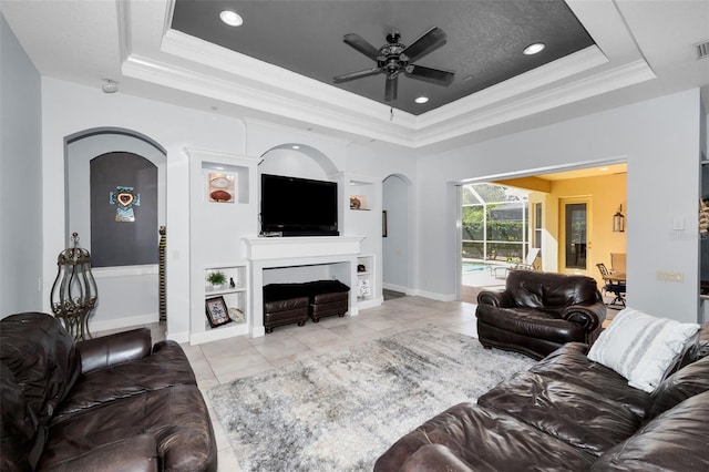 1033 Tuscany Dr, Trinity, FL 34655 - living area featuring a ceiling fan, a raised ceiling, a fireplace, and ornamental molding