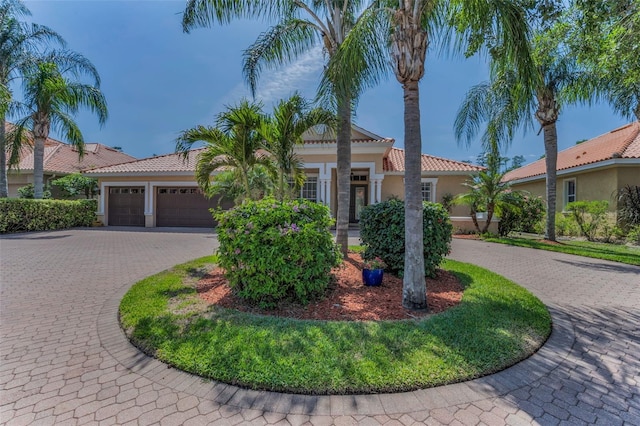1033 Tuscany Dr, Trinity, FL 34655 - view of front of home with curved driveway, stucco siding, an attached garage, and a tiled roof