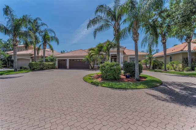 1033 Tuscany Dr, Trinity, FL 34655 - mediterranean / spanish house with curved driveway, an attached garage, stucco siding, and a tile roof