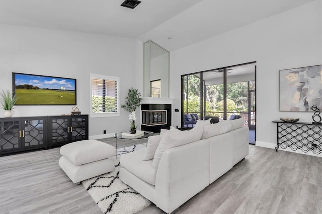 3047 Bolt Dr, Palm Harbor, FL 34685 - living area featuring wood finished floors, visible vents, high vaulted ceiling, and a healthy amount of sunlight