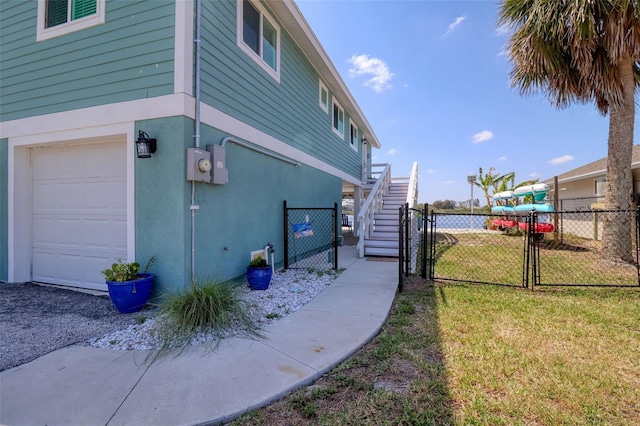 6622 Seaview Blvd, Hudson, FL 34667 - view of property exterior featuring a gate, an attached garage, stairway, and stucco siding
