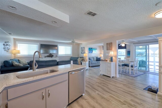 6622 Seaview Blvd, Hudson, FL 34667 - kitchen featuring a ceiling fan, stainless steel dishwasher, a textured ceiling, open floor plan, and light stone counters